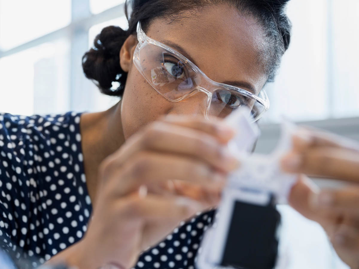 Woman scientist with safety glasses doing testing