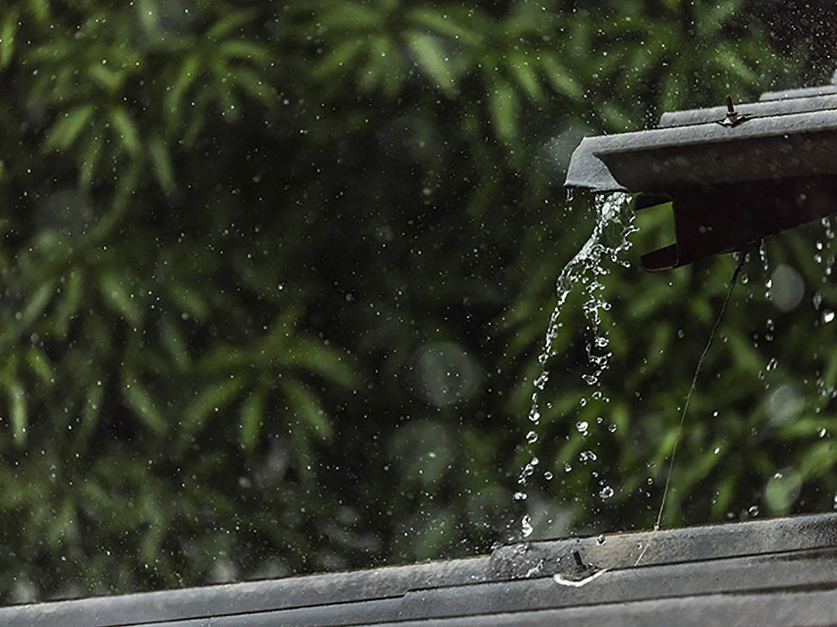 photo of rain draining off a tin roof