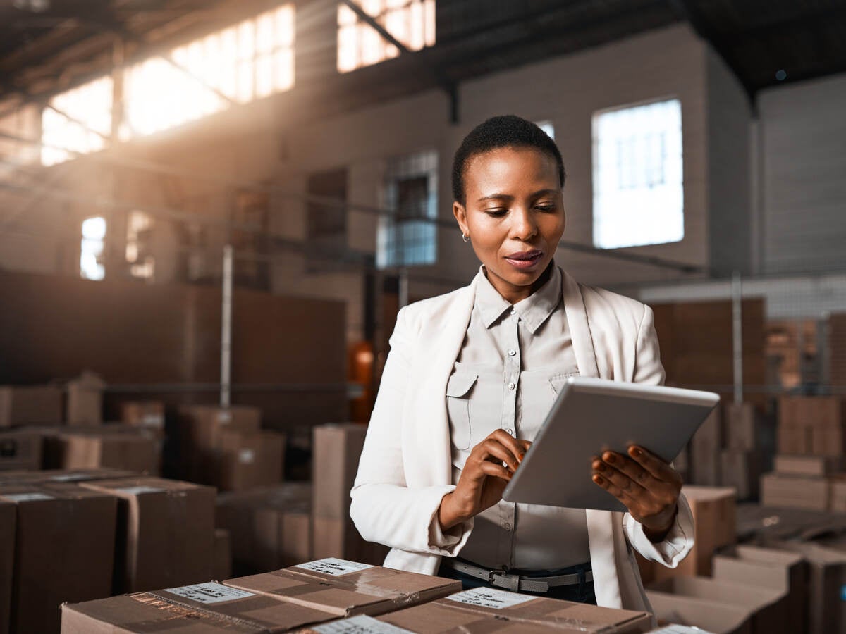 Factory manager using a digital tablet in a warehouse