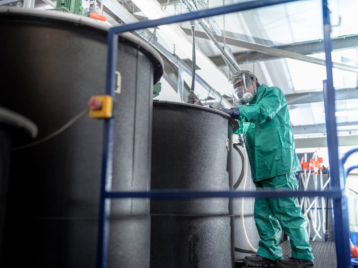 Worker at mixing tanks in chemical factory