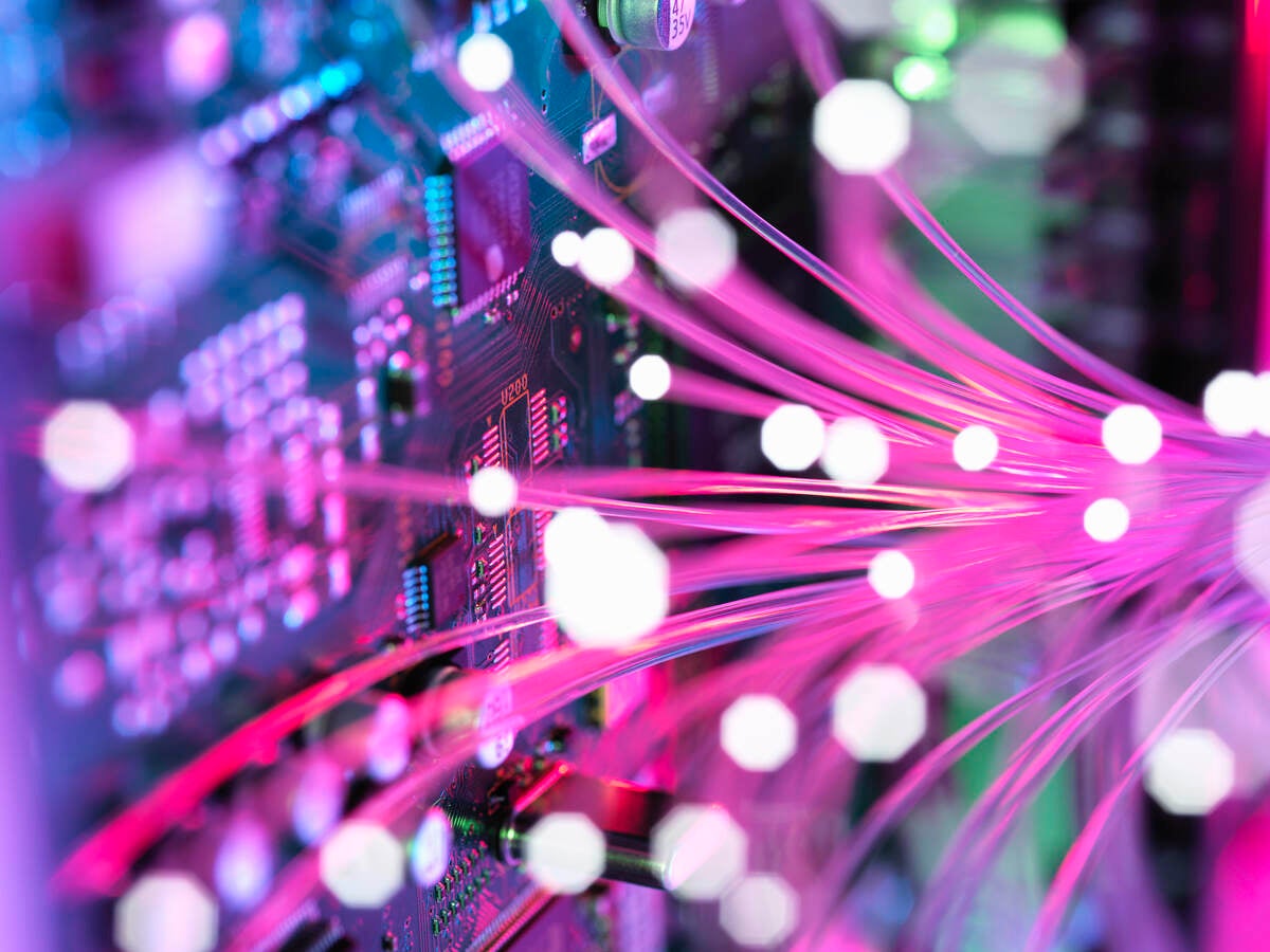 Pink colored fiber spreading into an electronic circuit board