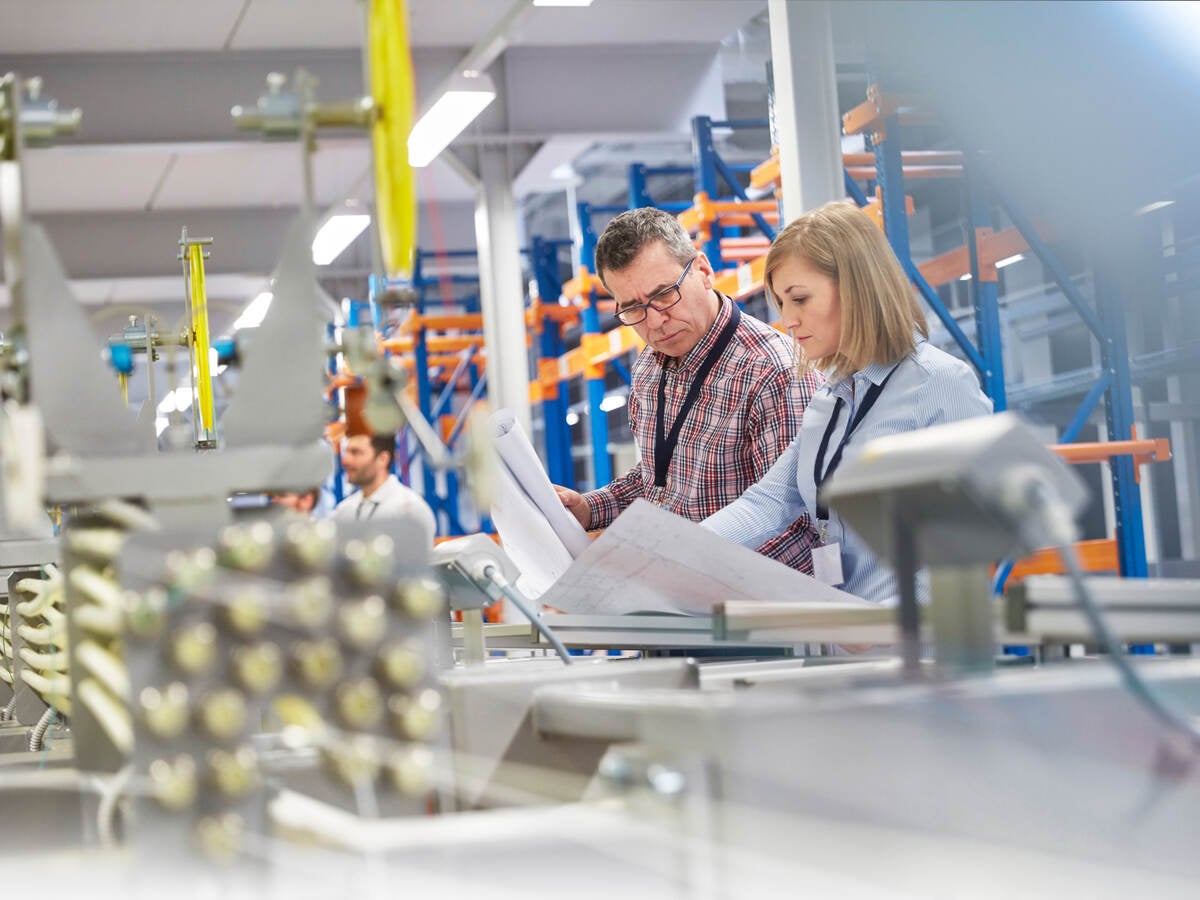 Supervisor and engineer discussing plans in fiber optics factory