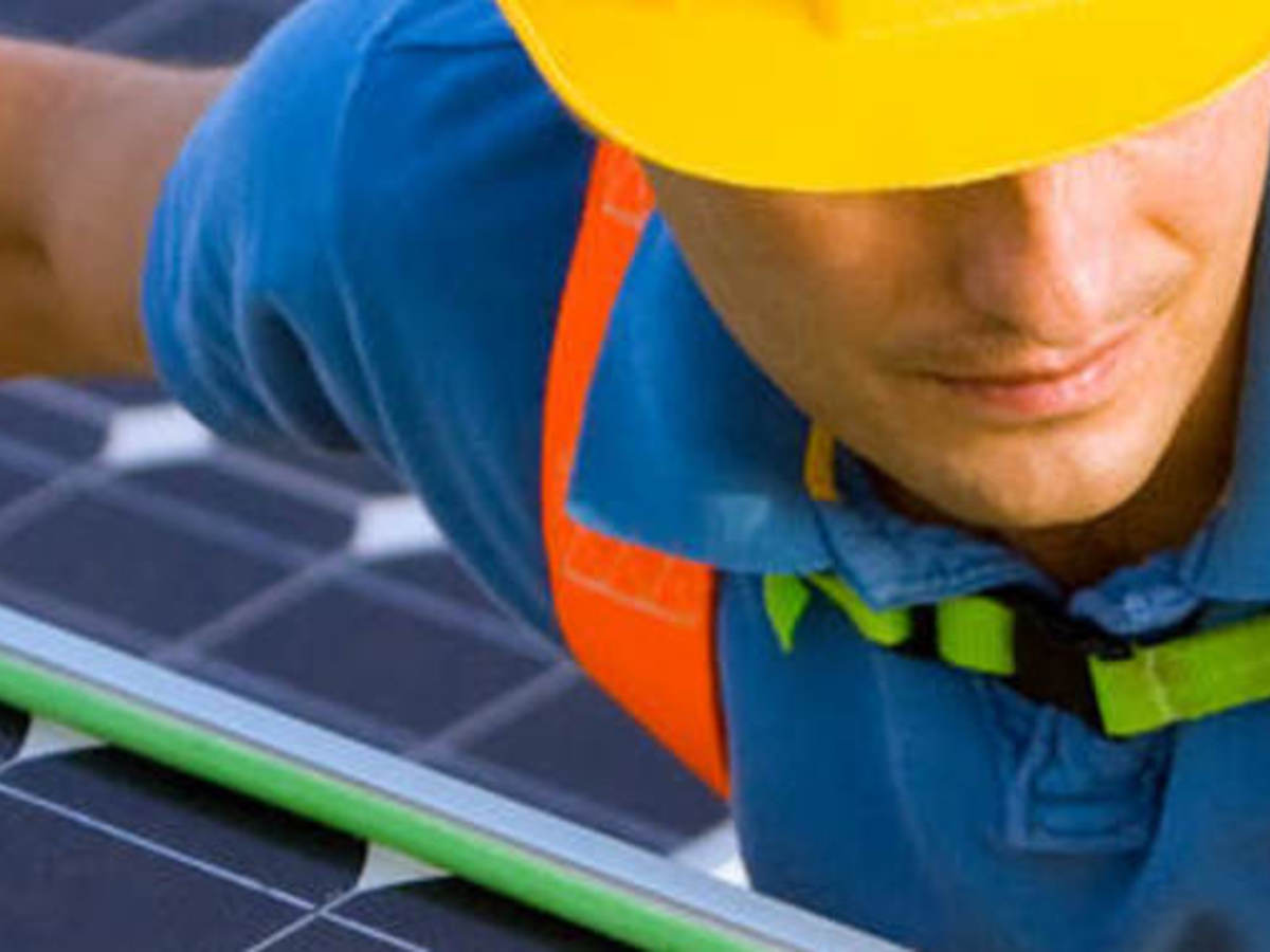 Man in hard hat doing wiring on a solar energy panel for wire and cable testing and certification