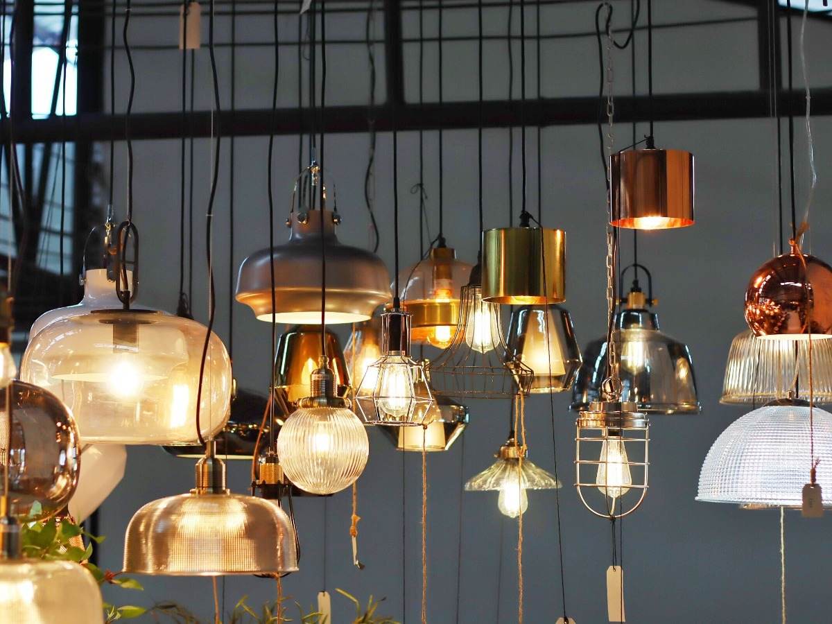 Variety of lamps and lightbulbs hanging from ceiling 