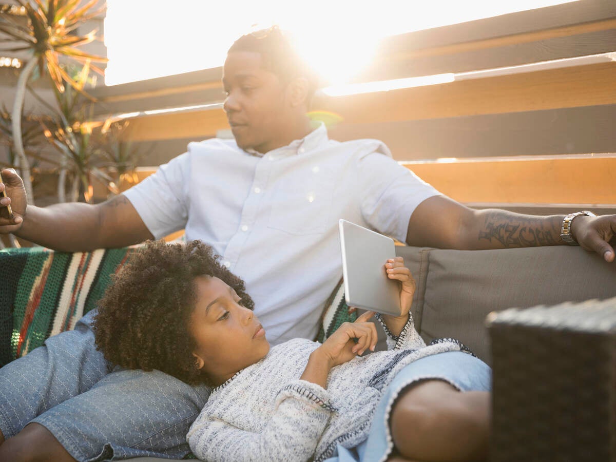 Parent relaxing with child using mobile devices