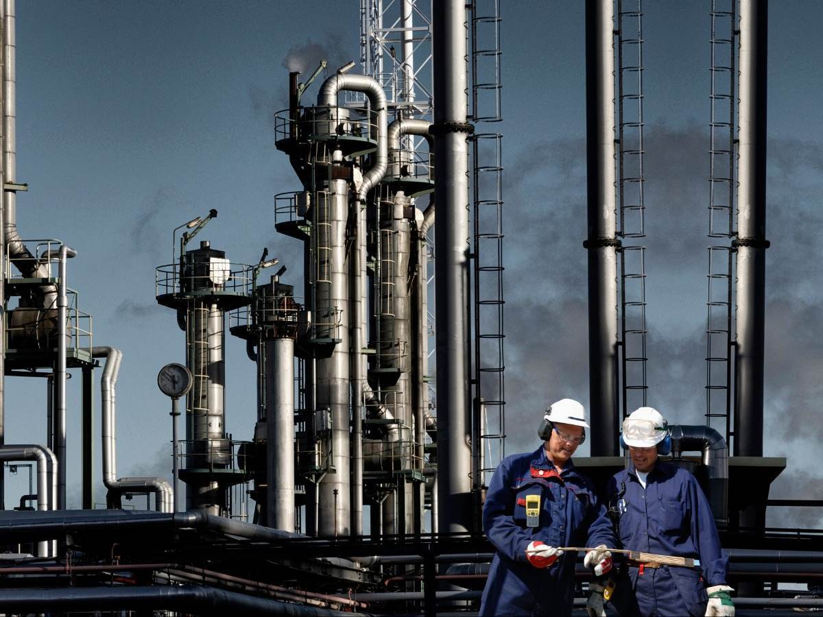 workers at oil refinery looking at papers