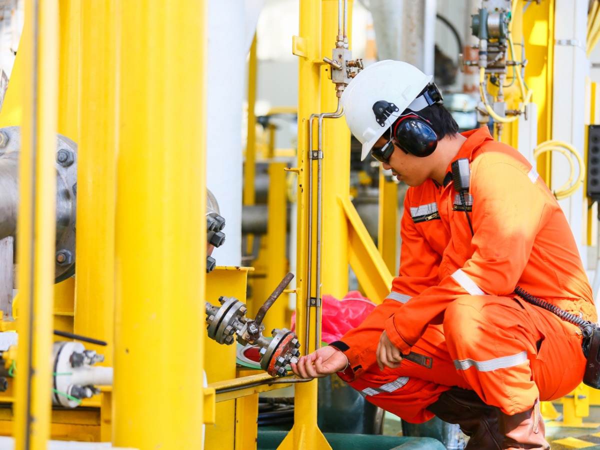 Oil rig worker checking gauge
