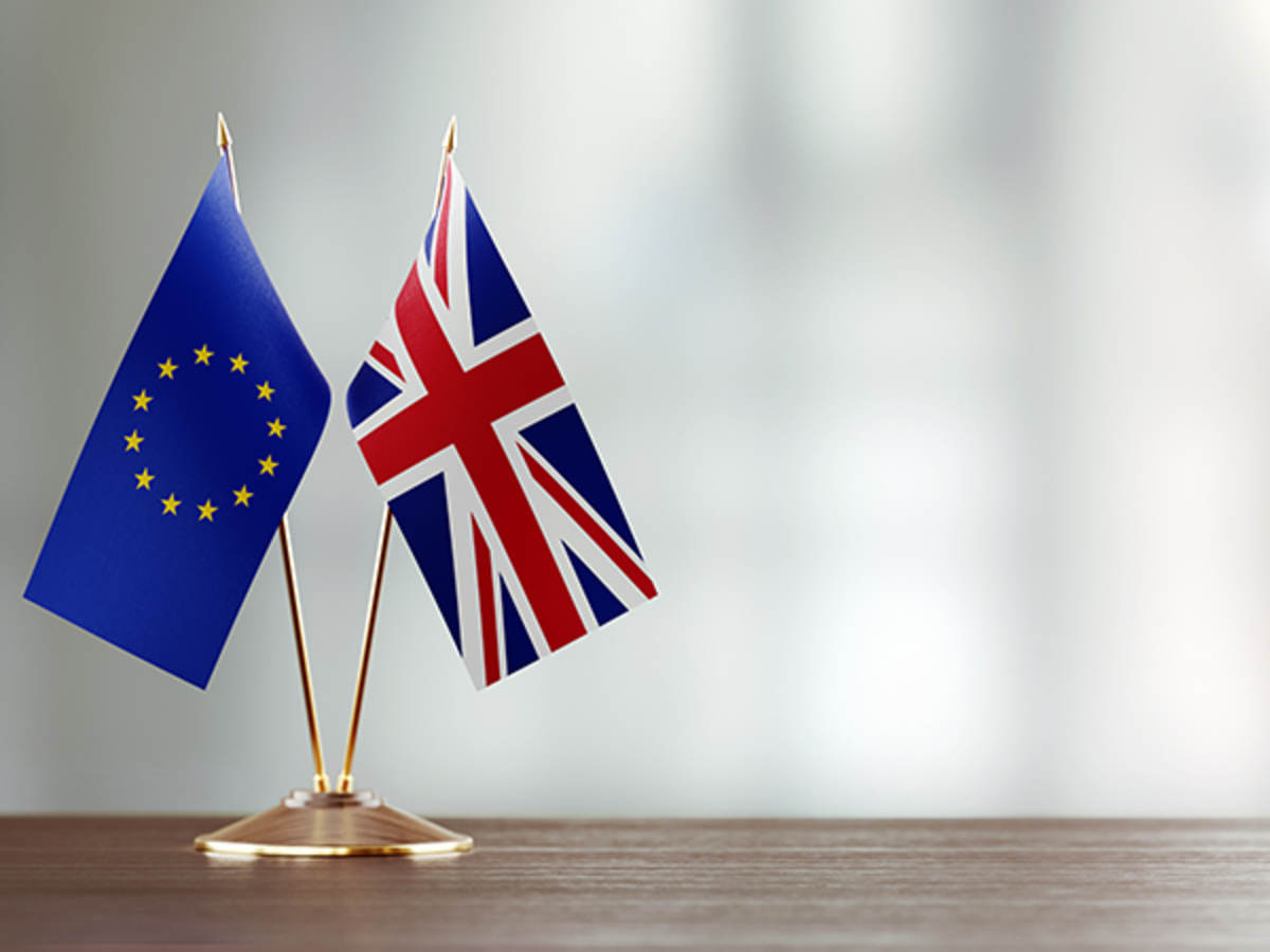 European union and British flag pair on a desk over defocused background