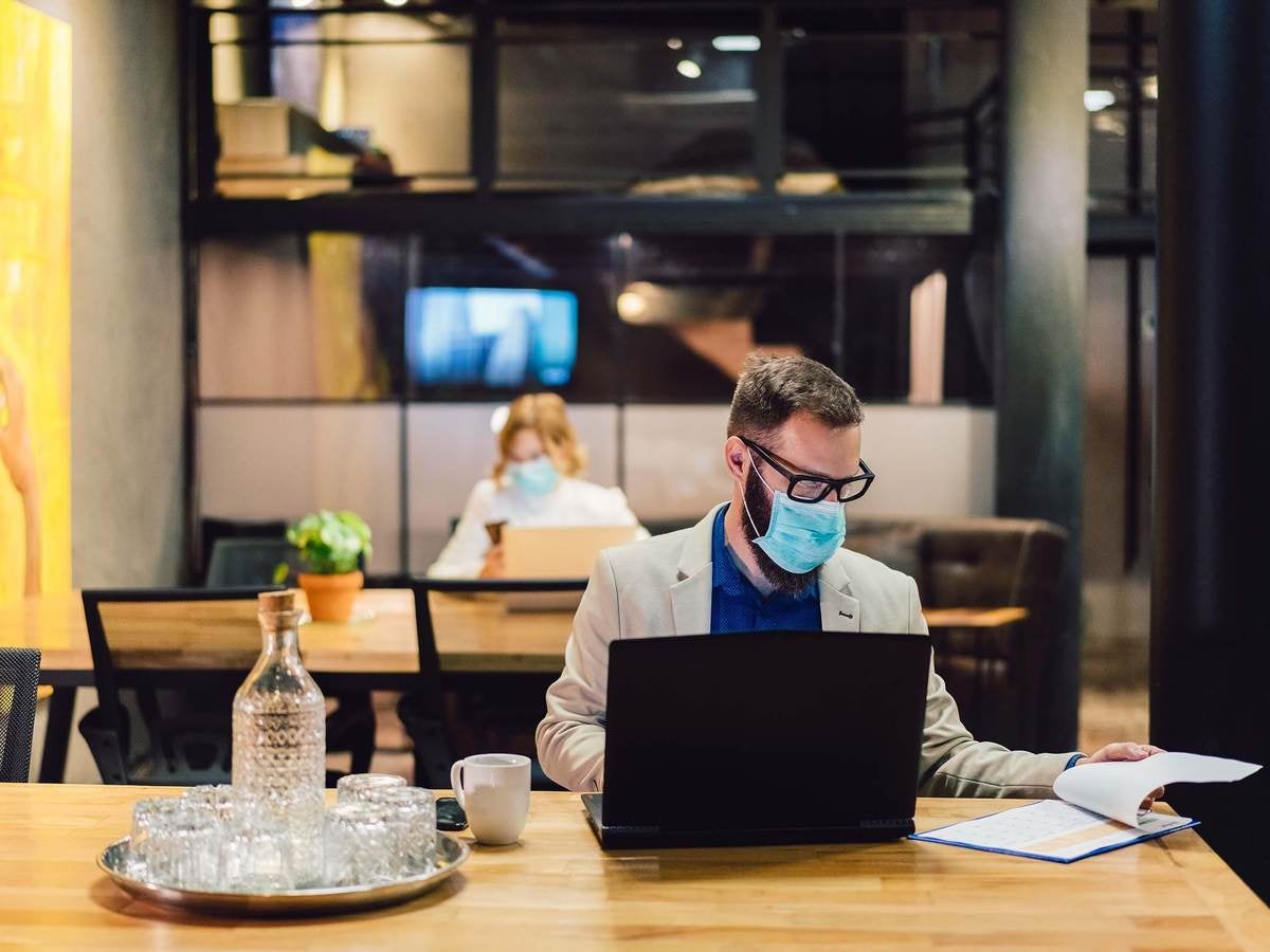 Workers in commercial real estate building wearing proper personal protective equipment and following safety guidelines 