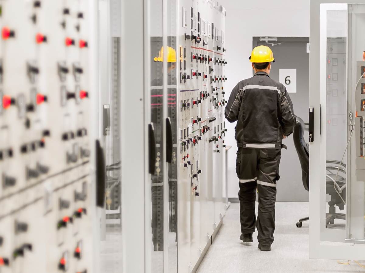 Engineer using protective relay and medium voltage switchgear in a bay control unit.
