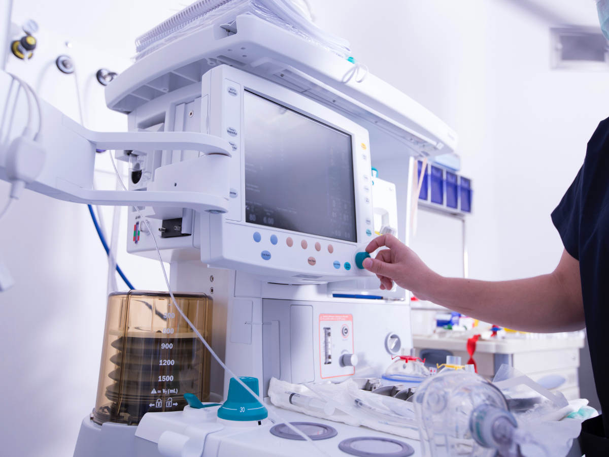 Technician monitoring equipment in hospital operating room