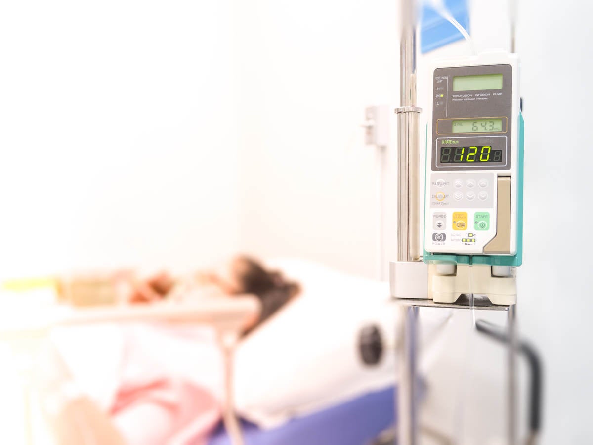 Patient in hospital bed on infusion pump