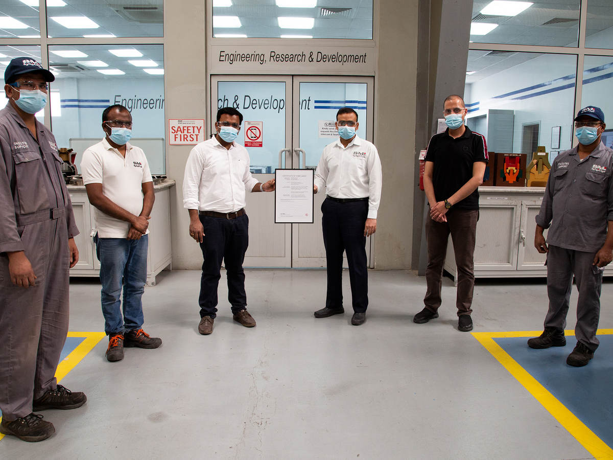 Saudi Mechanical Industries manufacturing facility in Saudi Arabia staff holding certificate