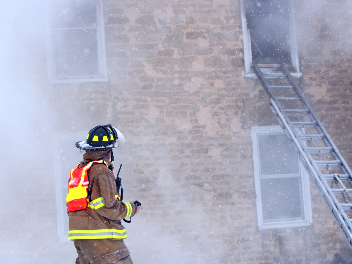 firefighter with radio at burning building