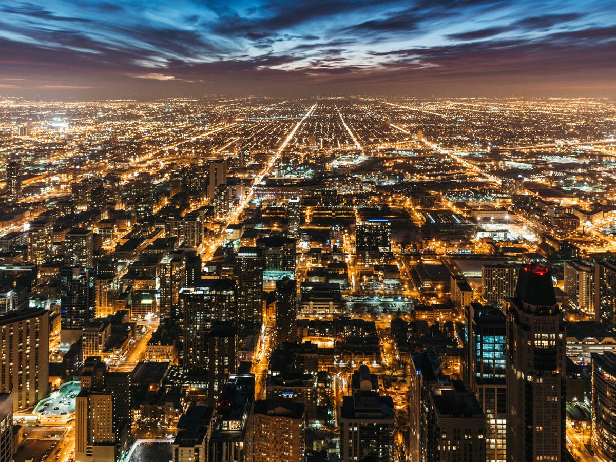 Cityscape at night with many lights from homes, businesses, roads