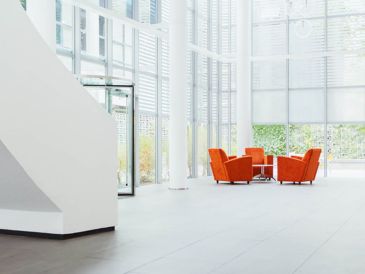 Stairs and orange chairs in a modern glass office building