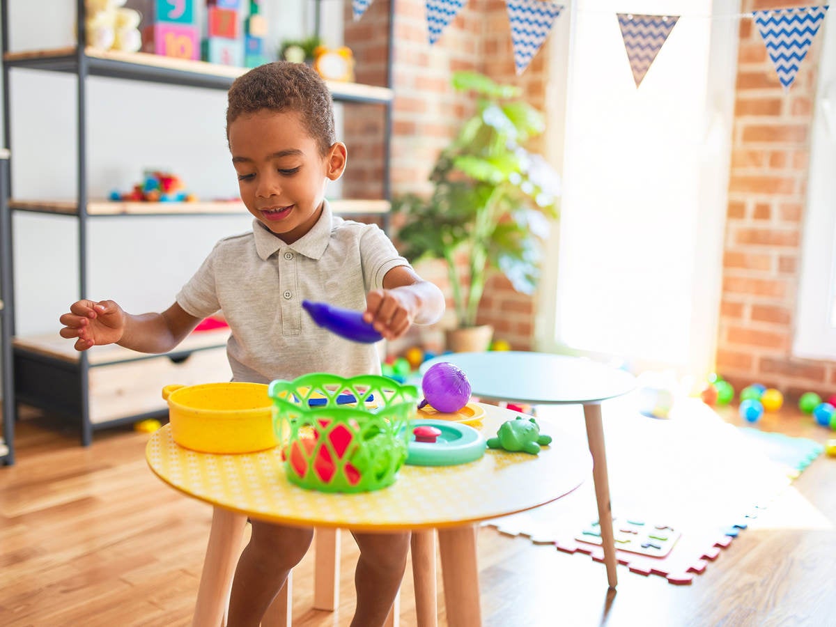 Child playing with plastic food and cutlery toys