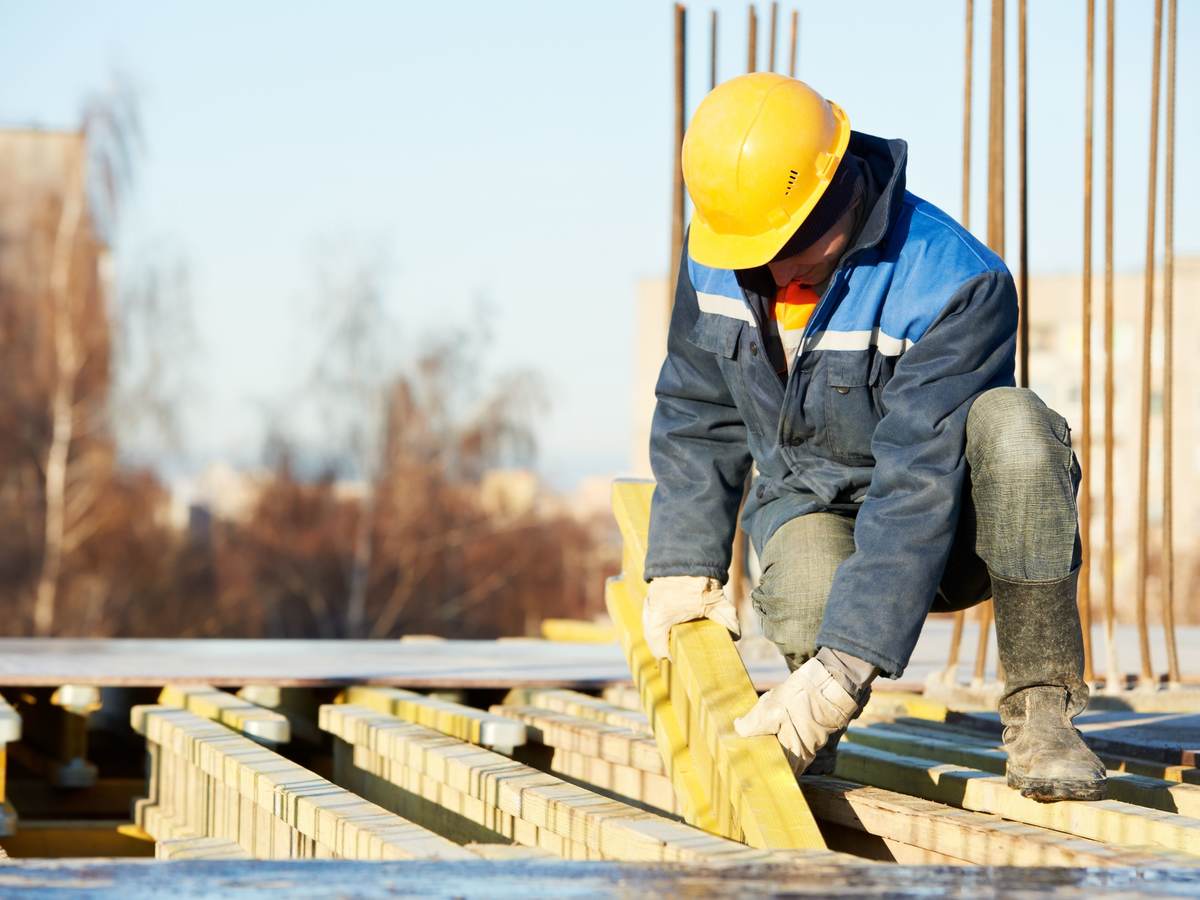 Construction worker with hardhat placing joists