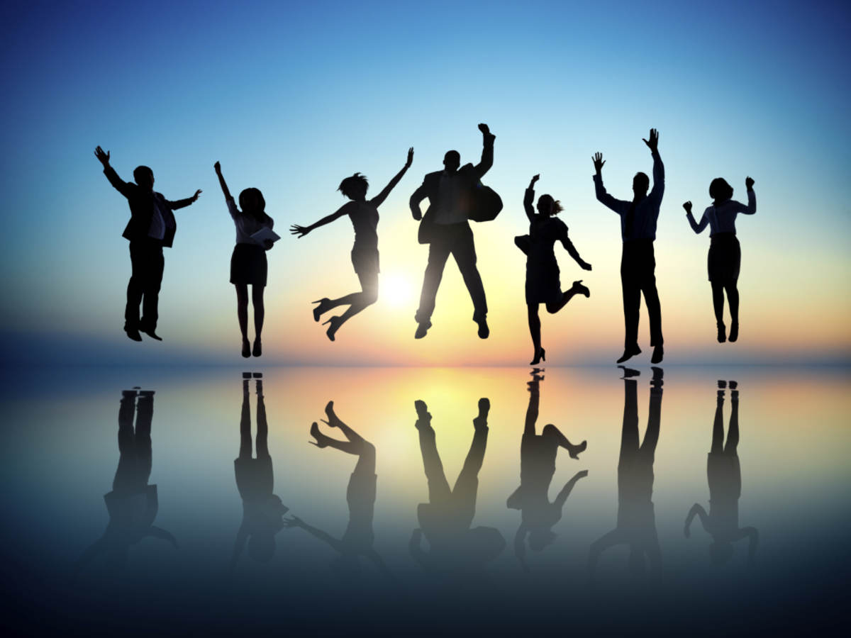 Group of people jumping in front of a sunset