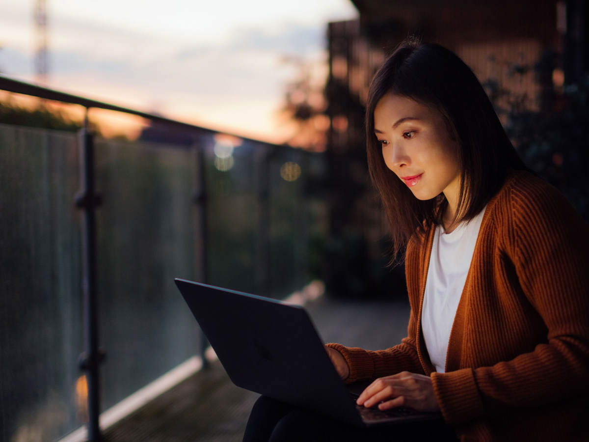 Woman using a laptop at dusk
