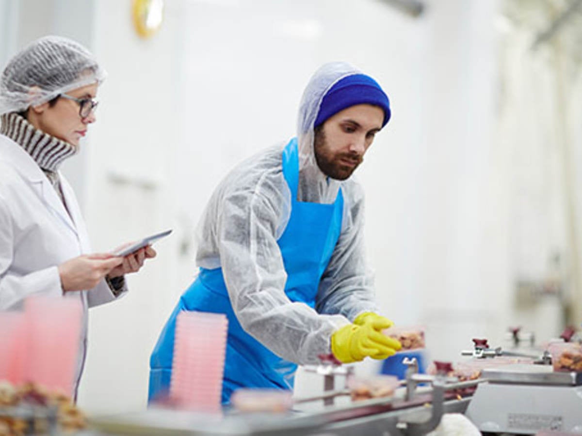 Man with blue beanie looks over food contact materials 