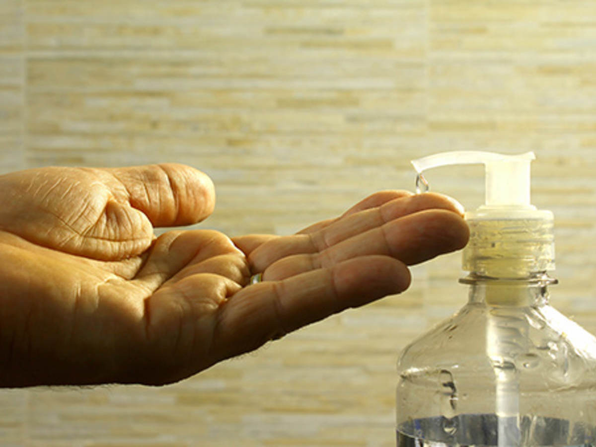 Hand held out under hand sanitizer nozzle 