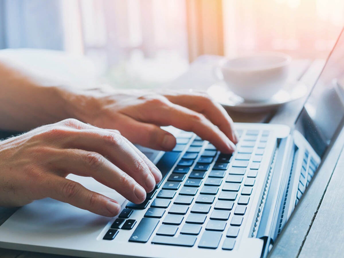 Hands typing on a laptop keyboard