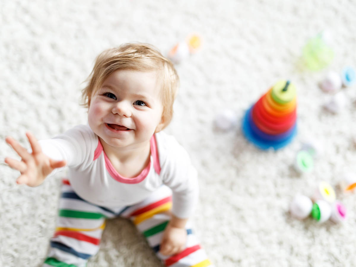 Smiling child surrounded by toys.