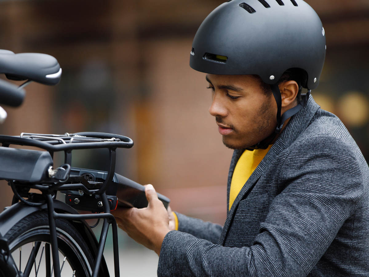 Young man changing battery pack on electric bicycle