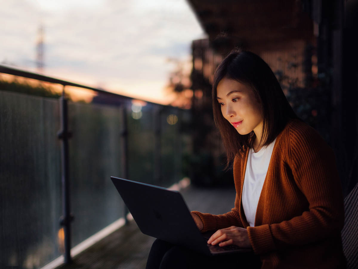 Woman using a laptop at dusk