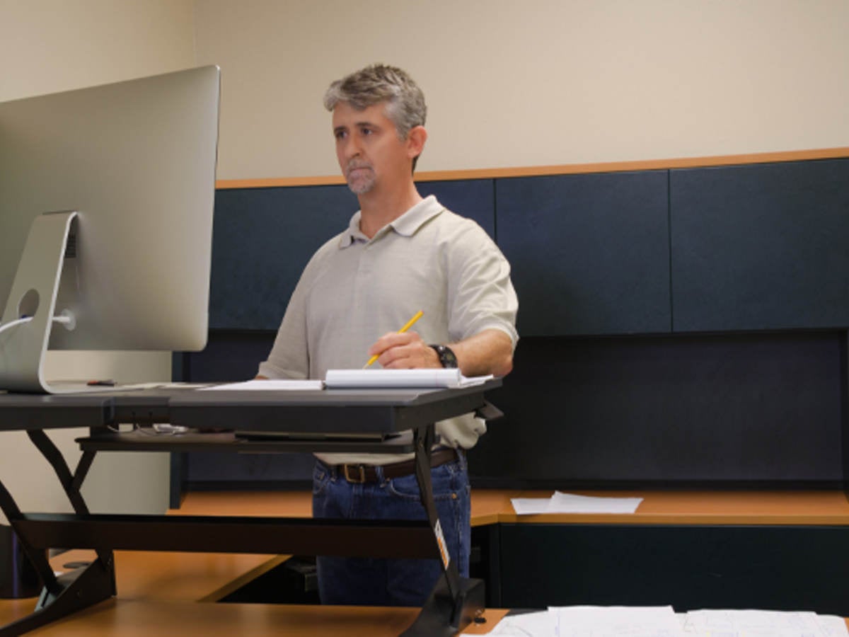 Man using stand up desk in office for good health