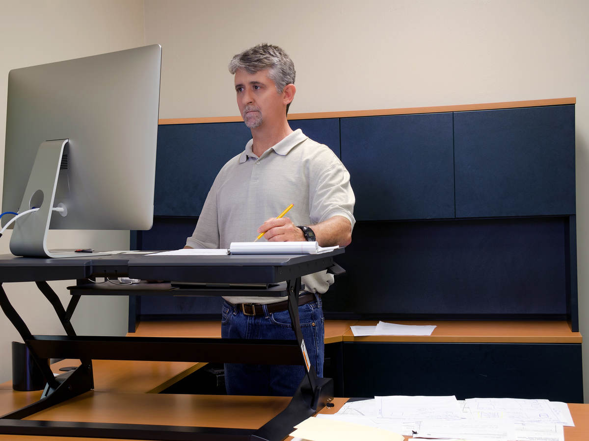 Man using stand up desk in office for good health