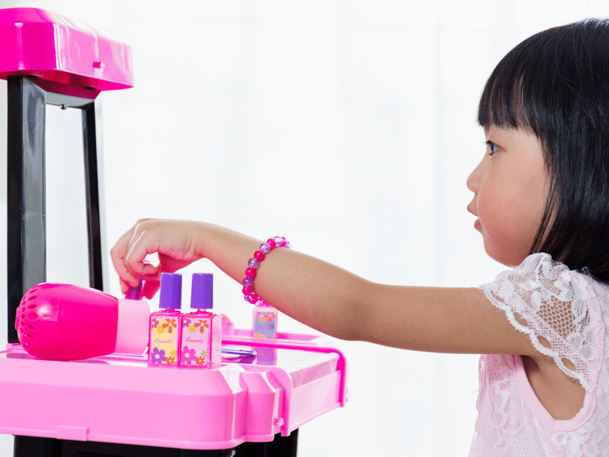 Little girl playing with cosmetic toys