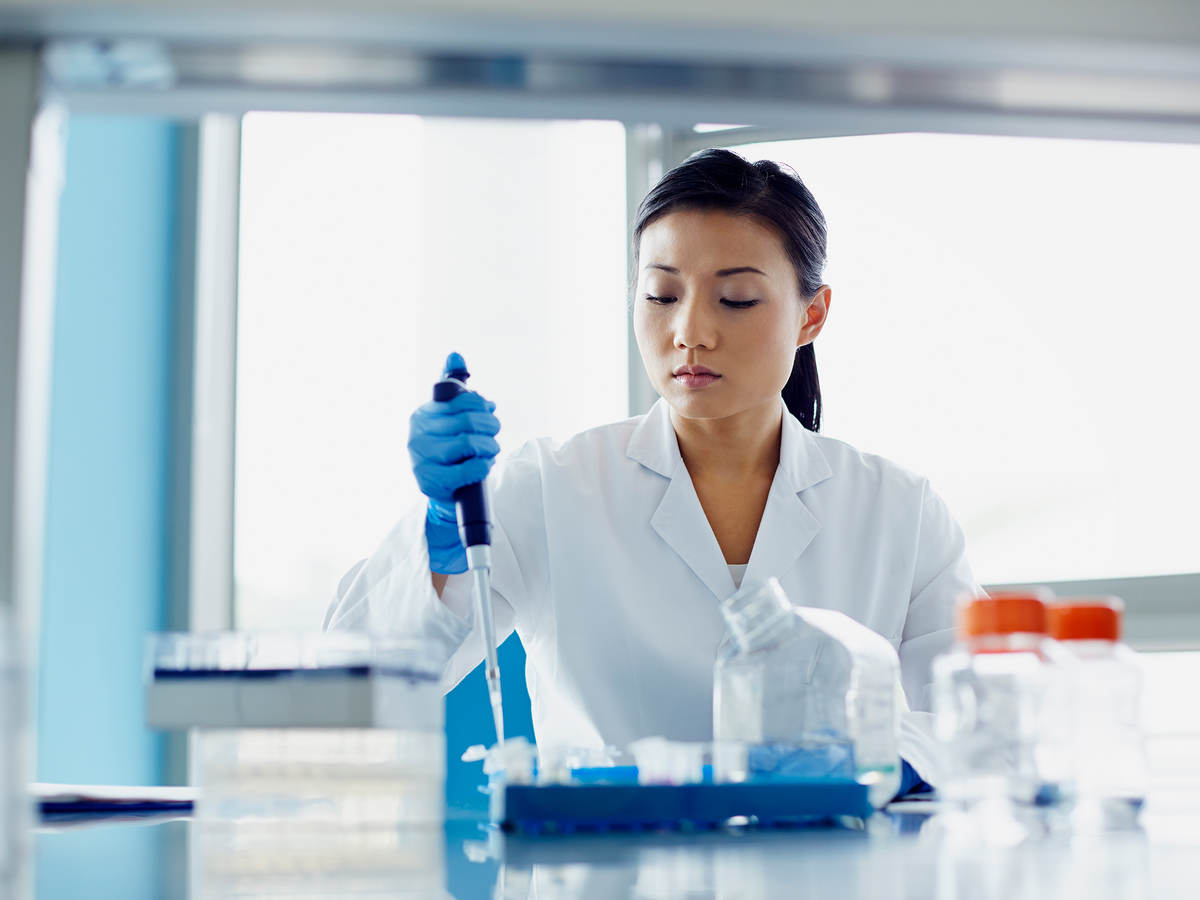 worker in laboratory using dropper