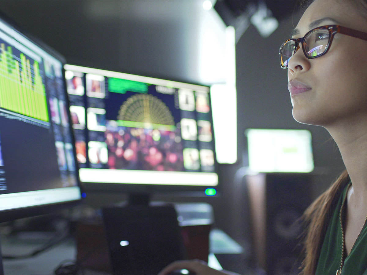 Close up image of a young Asian woman with monitors
