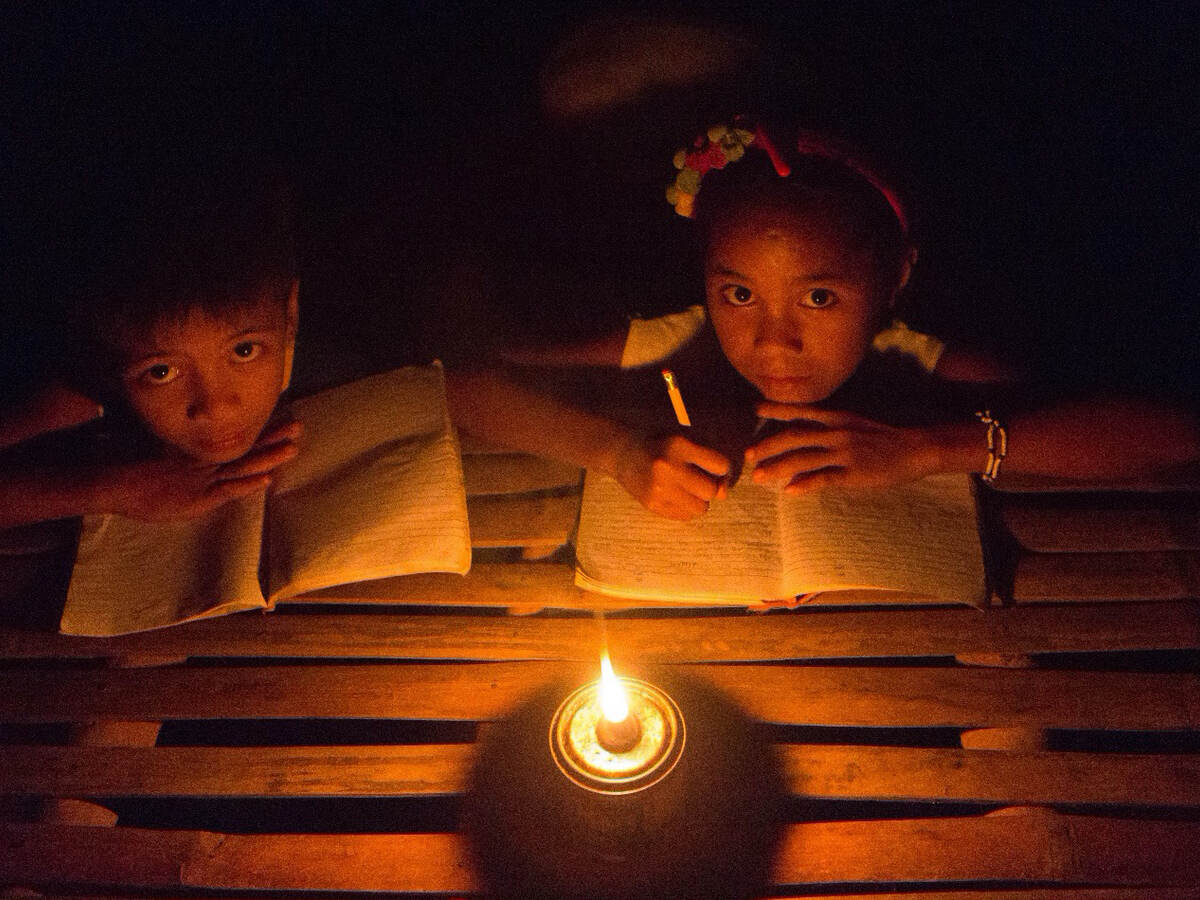 Children studying by kerosene lamp