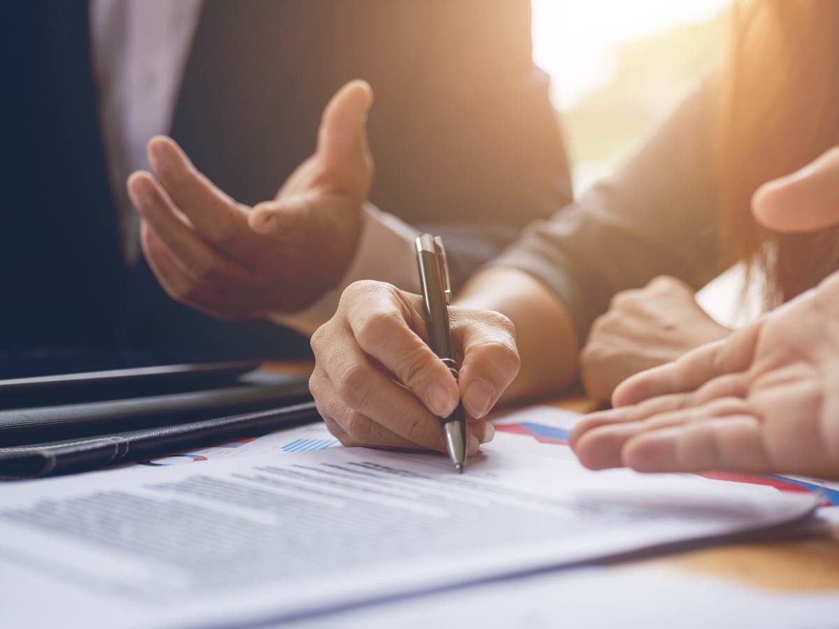 People at a desk signing a contract