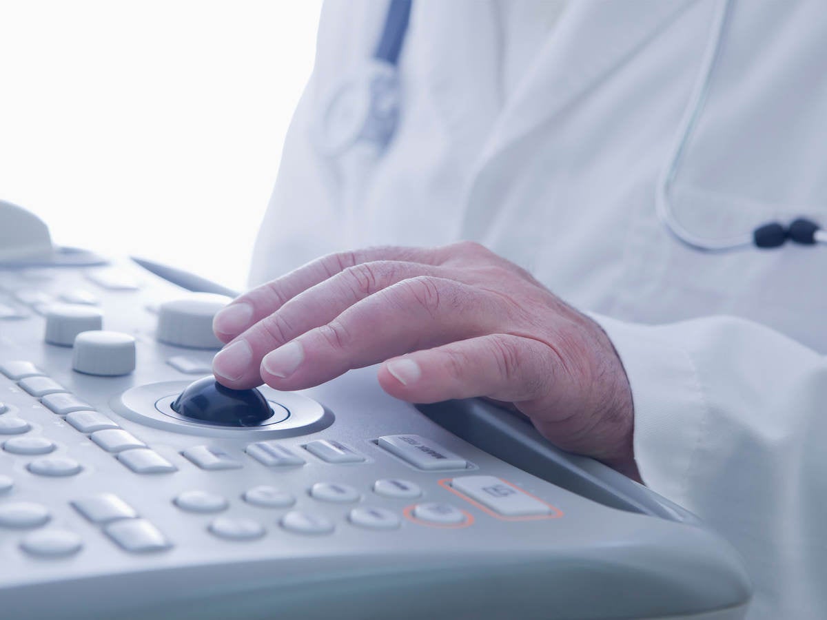 A doctor operates an ultrasound scanner