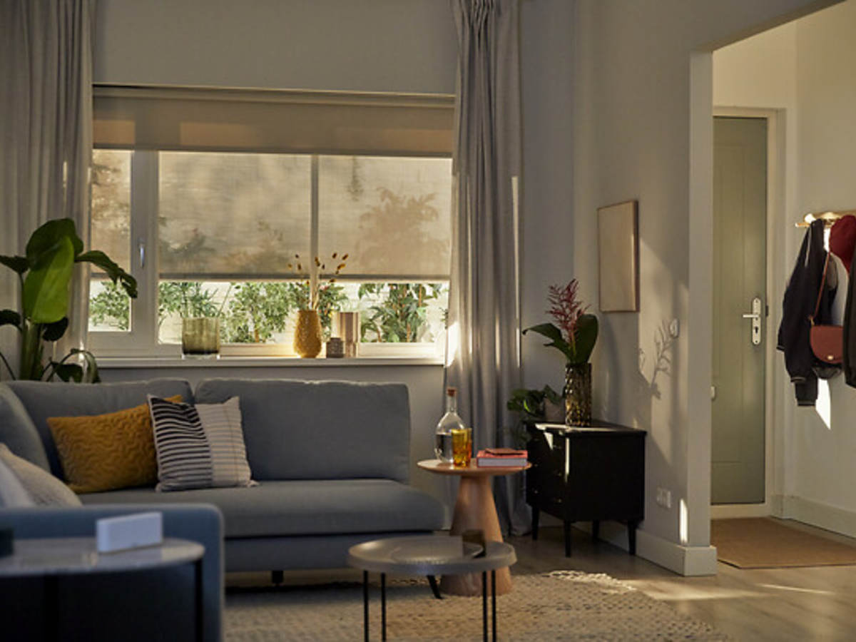 contemporary living room with smart shades, curtains and the Somfy device on an end table