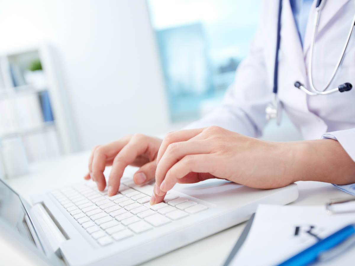 Doctor typing on a laptop