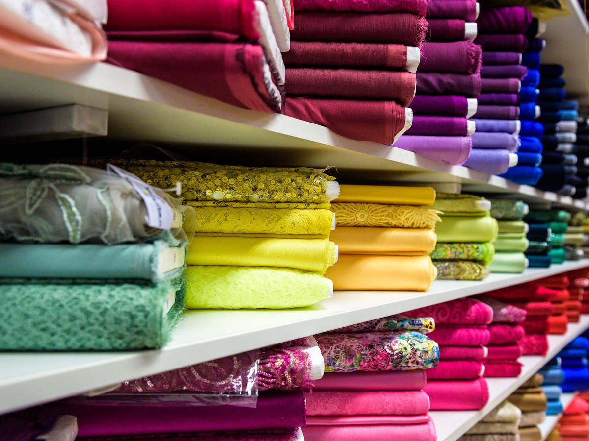 Colorful textiles folded on shelves 