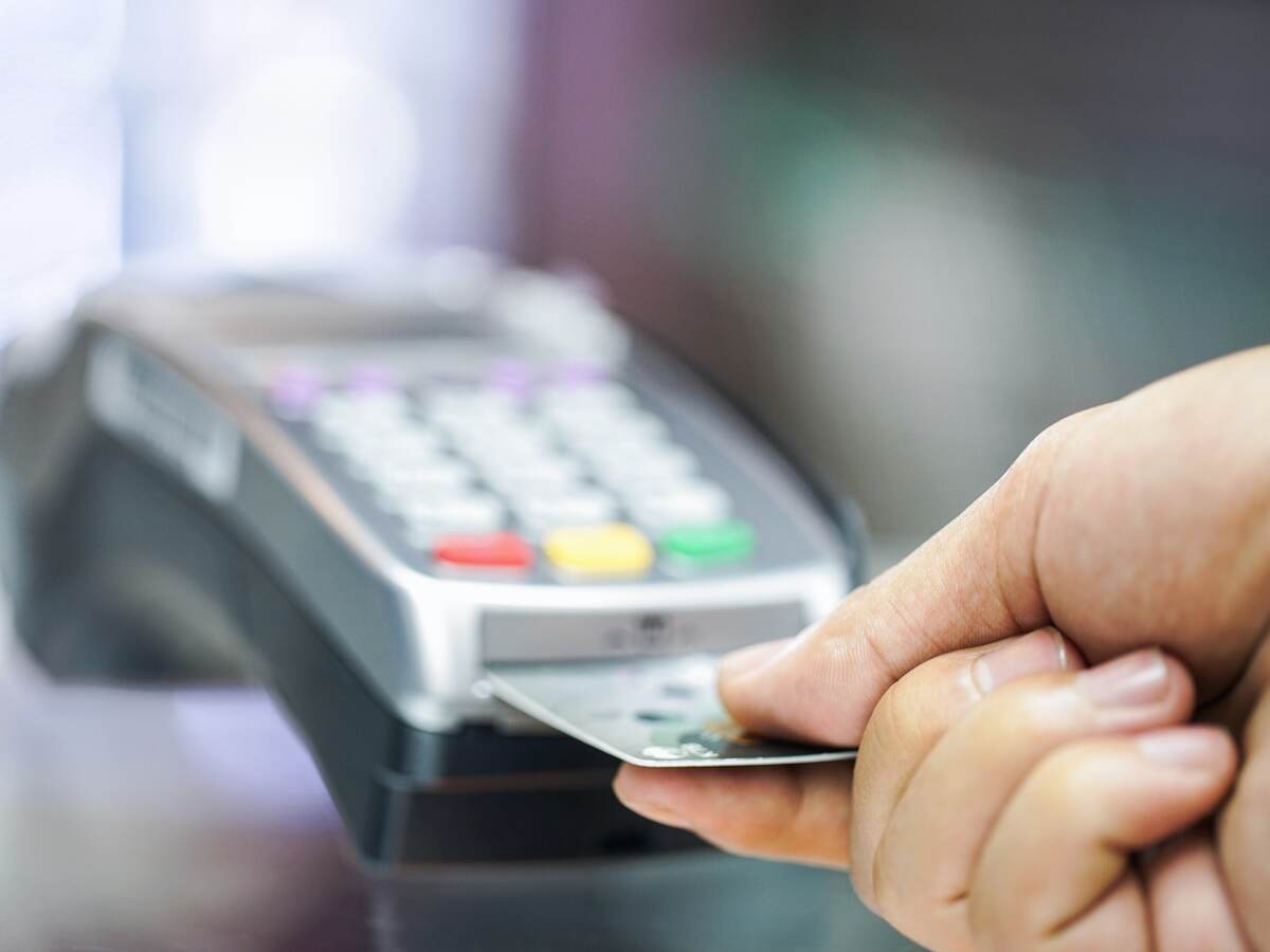 man inserting a credit card into a payment terminal