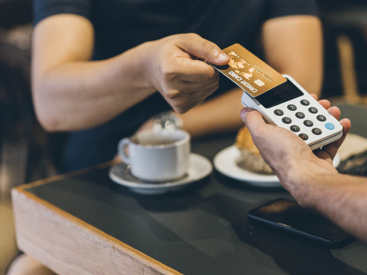 man paying with a credit card in cafe