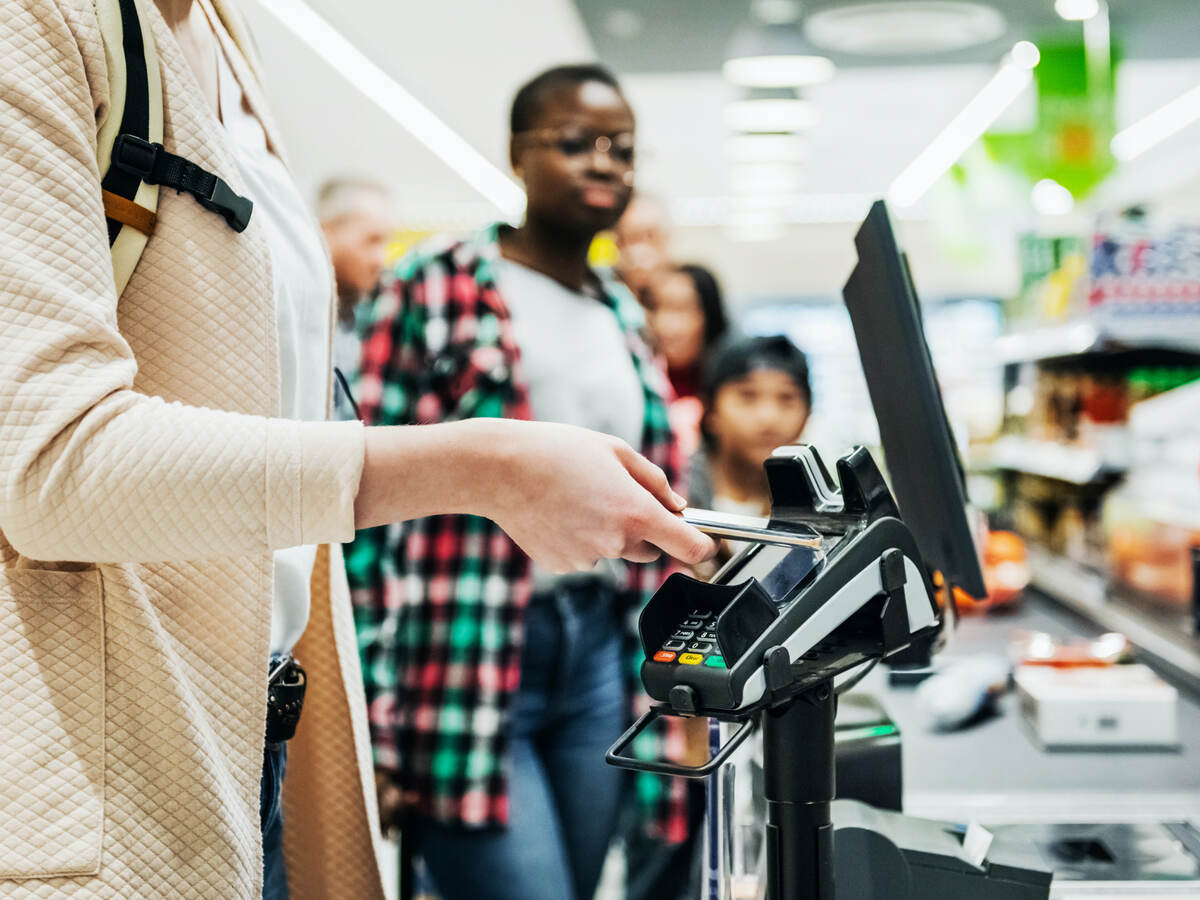 woman using a mobile phone to pay for groceries