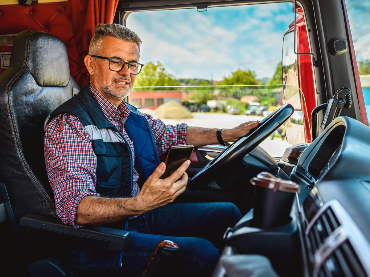 man looking at a mobile phone in the truck