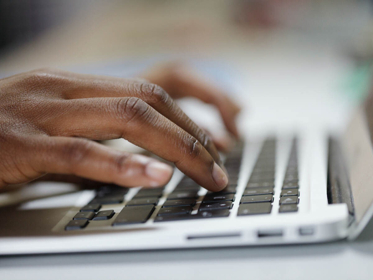 man typing on laptop keyboard