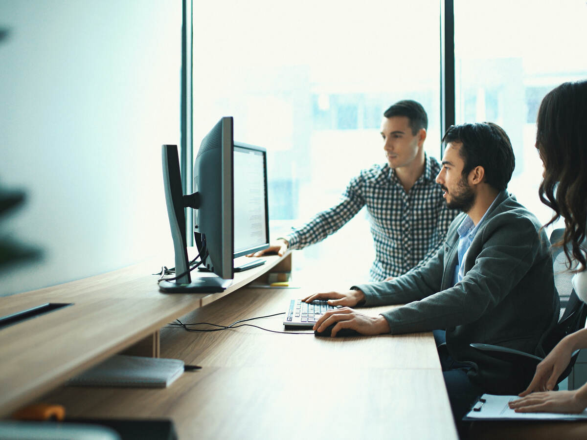 people in front of computer monitors at office
