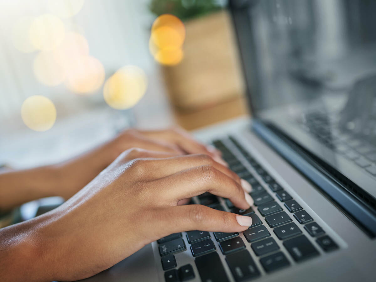 man typing on laptop keyboard