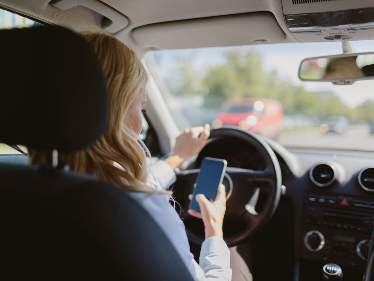 woman looking at a mobile phone in car