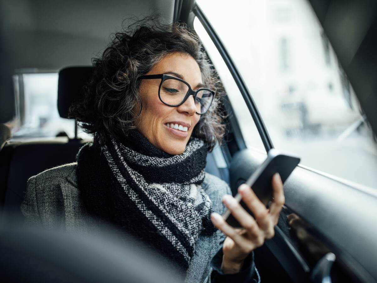 woman looking at a mobile phone in car